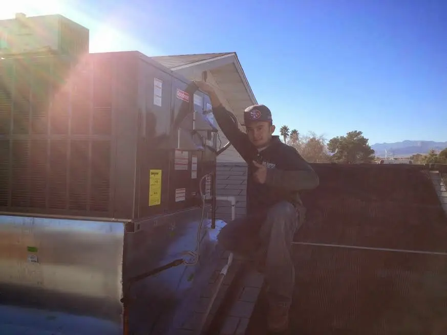 HVAC technician performing AC Tune-Up on a rooftop unit in Briarcliff Manor
